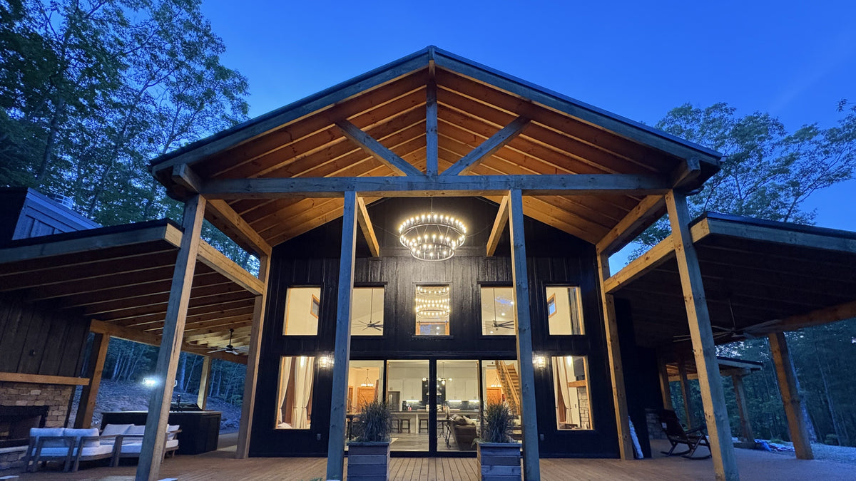 Modern house with wooden exterior and large windows at night.